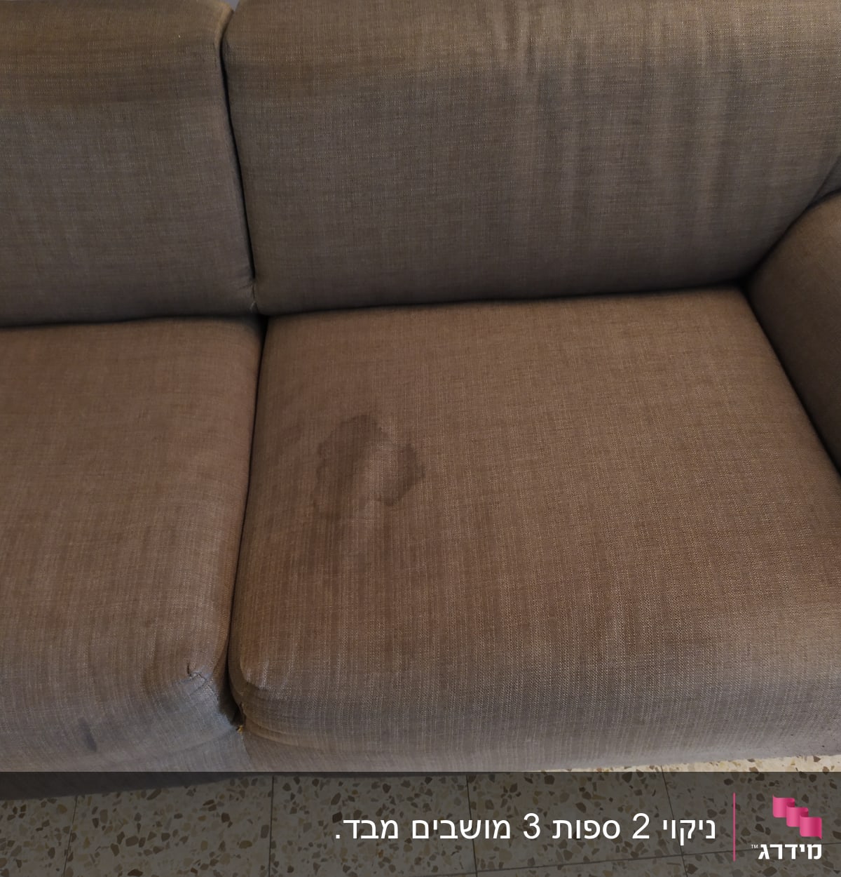 כתם על ספה חומה עם ריפוד בד